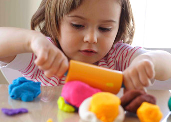 child playing with playdough