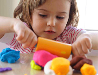 child playing playdough